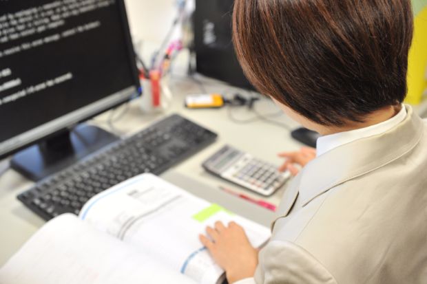 電卓をたたいてる画像